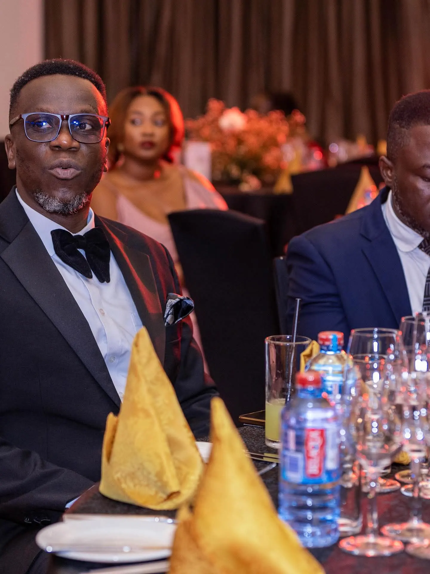 Prince Douglas Asamany in a tuxedo seated at the Philanthropic Awards & Charity Night gala dinner