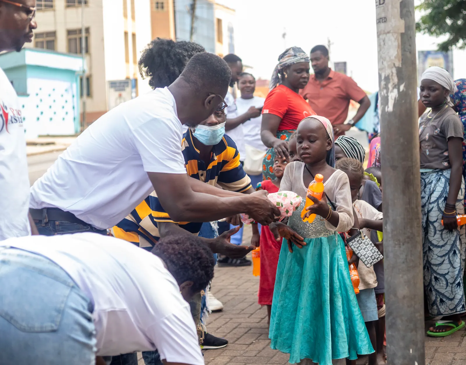 Foundation volunteers handing relief items to mothers and children during a Joy to the Street outreach in Kumasi