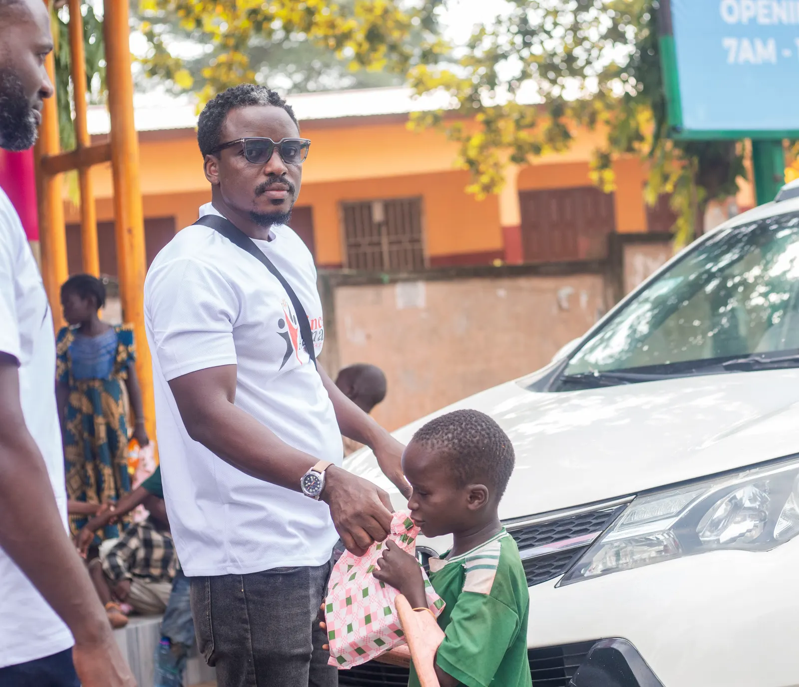 Prince Asamany sharing a care package with a child during outreach
